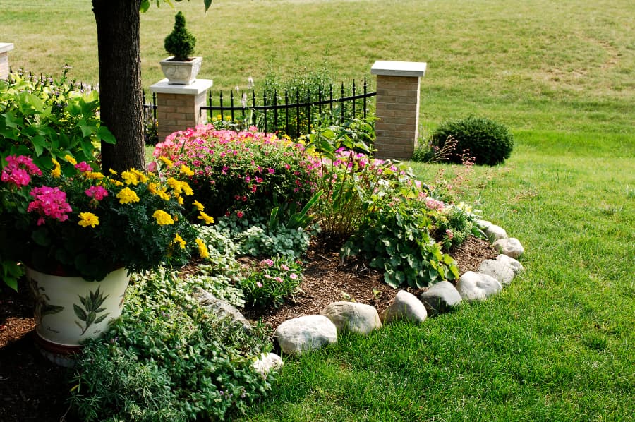 Flower garden with rock border next to grass